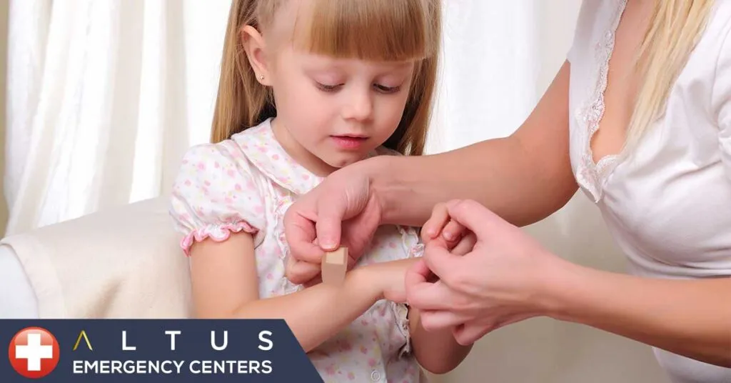 woman applying bandaid on child