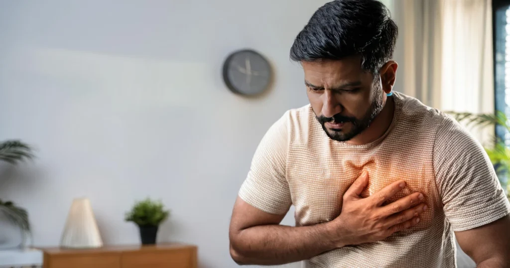 Man clutching his chest in pain with a red glowing effect highlighting severe chest distress.
