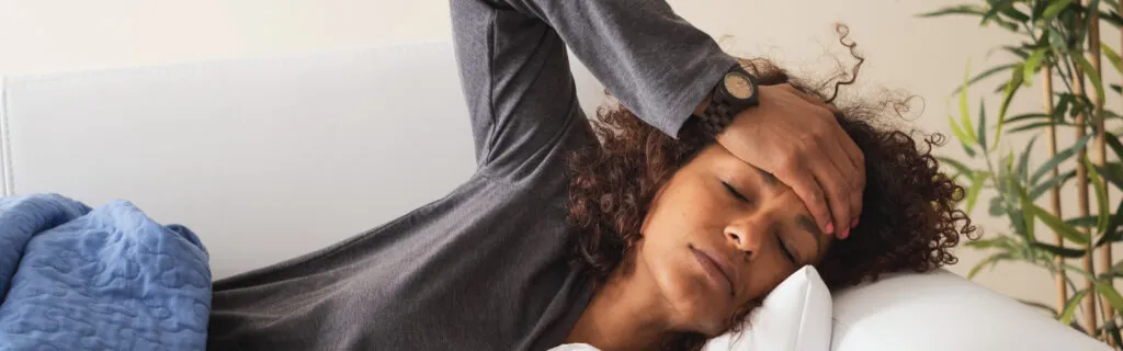 woman touching her forehead checking for a fever