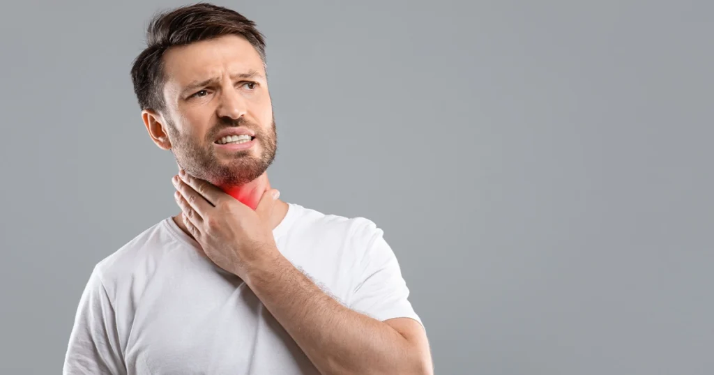 Man touching painful throat area showing laryngitis symptoms.