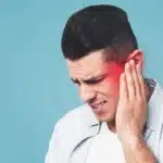 Man holding his ear in pain with a red highlight indicating earache.