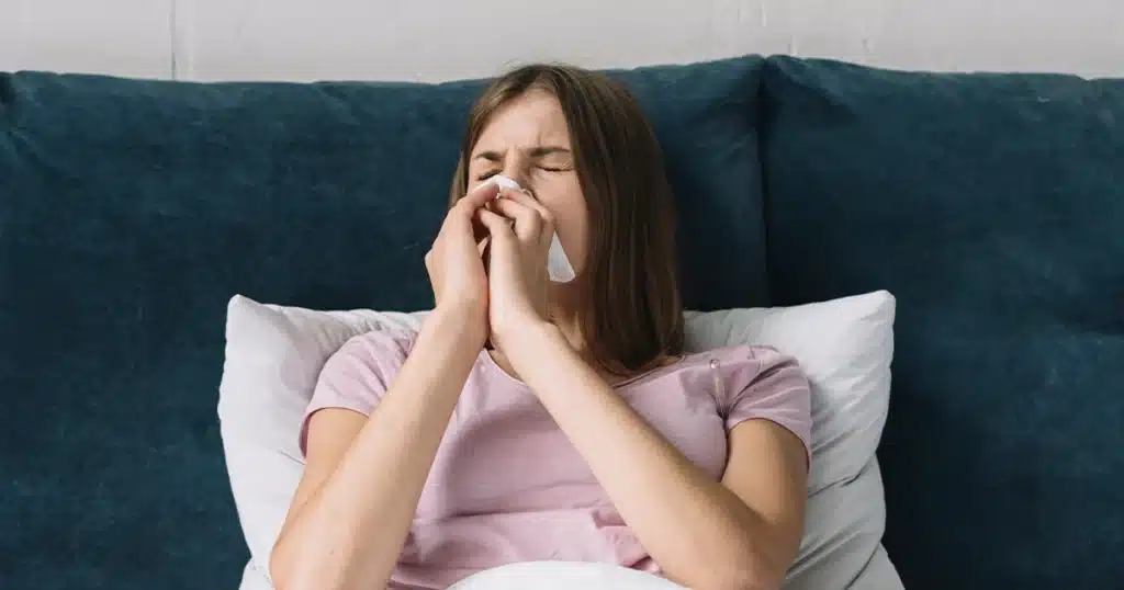 Person struggling to breathe in bed with congestion.
