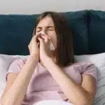 Person struggling to breathe in bed with congestion.