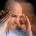 Man holding his head with blurred motion, showing stroke symptoms.