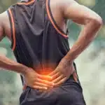 Man holding lower back with highlighted pain area.