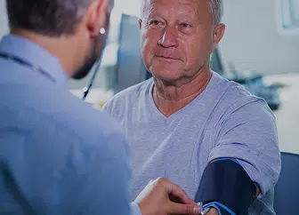 A healthcare professional checking a senior patient's blood pressure