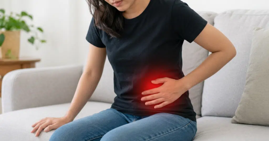 Woman holding her lower left abdomen in pain.