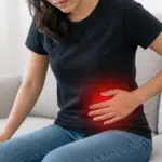 Woman holding her lower left abdomen in pain.