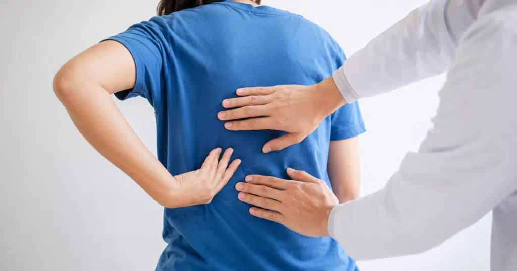 Doctor examining a patient with middle back pain.