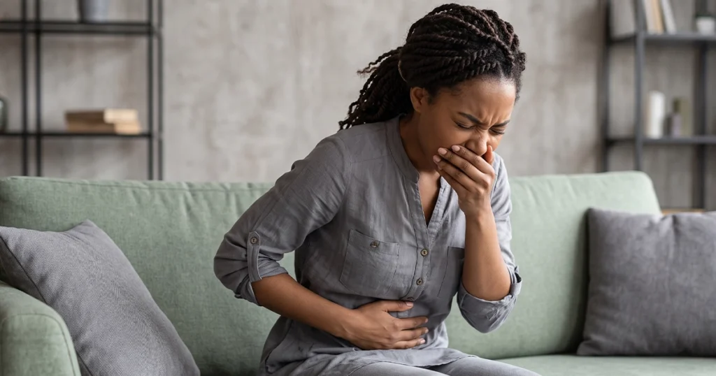 Woman experiencing nausea and stomach cramps