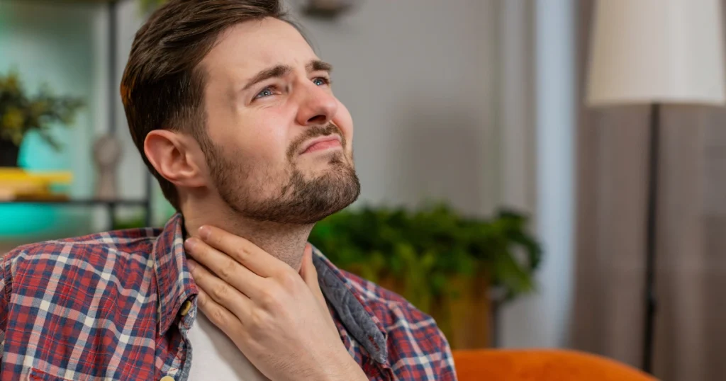Man experiencing sore throat from strep