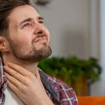 Man experiencing sore throat from strep